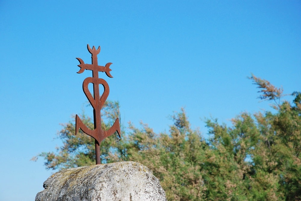 Cruz de Camarga: la cruz que reúne los símbolos de las virtudes teologales